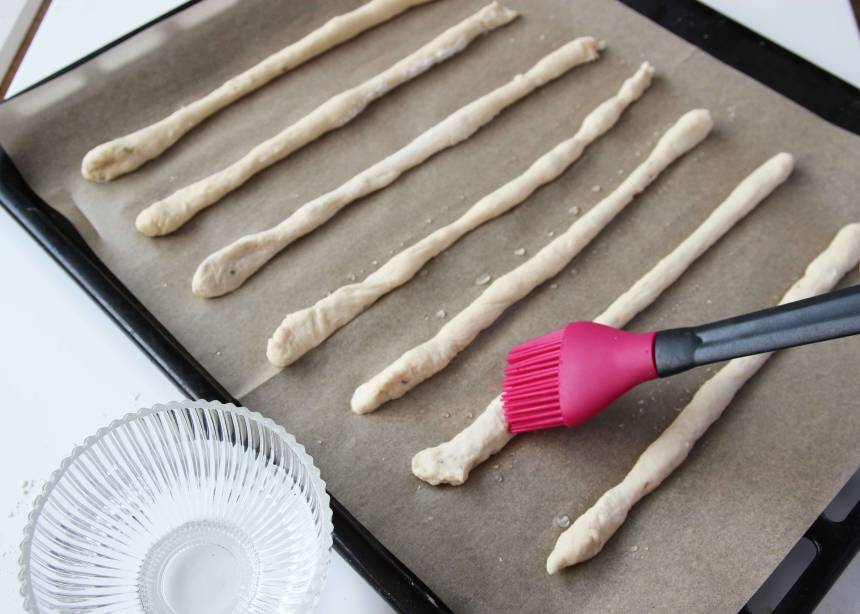 3. Lägg längderna på en plåt med bakplåtspapper. Låt dem jäsa under bakduk i ca 20 min. Sätt ugnen på 250 grader. Pensla pinnarna med vatten.