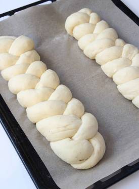 4. Lägg flätorna på en plåt med bakplåtspapper. Låt dem jäsa under bakduk i ca 30 min. Sätt ugnen på 200 grader. Pensla flätorna med uppvispat ägg och grädda dem mitt i ugnen i 15–20 min.