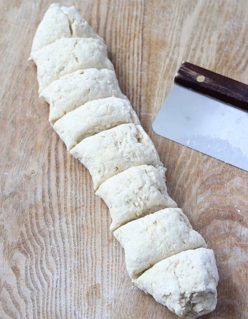 2. Rulla degen till en rulle på ett mjölat bakbord. Dela den i åtta lika stora bitar på ett mjölat bakbord. Rulla dem till bollar.