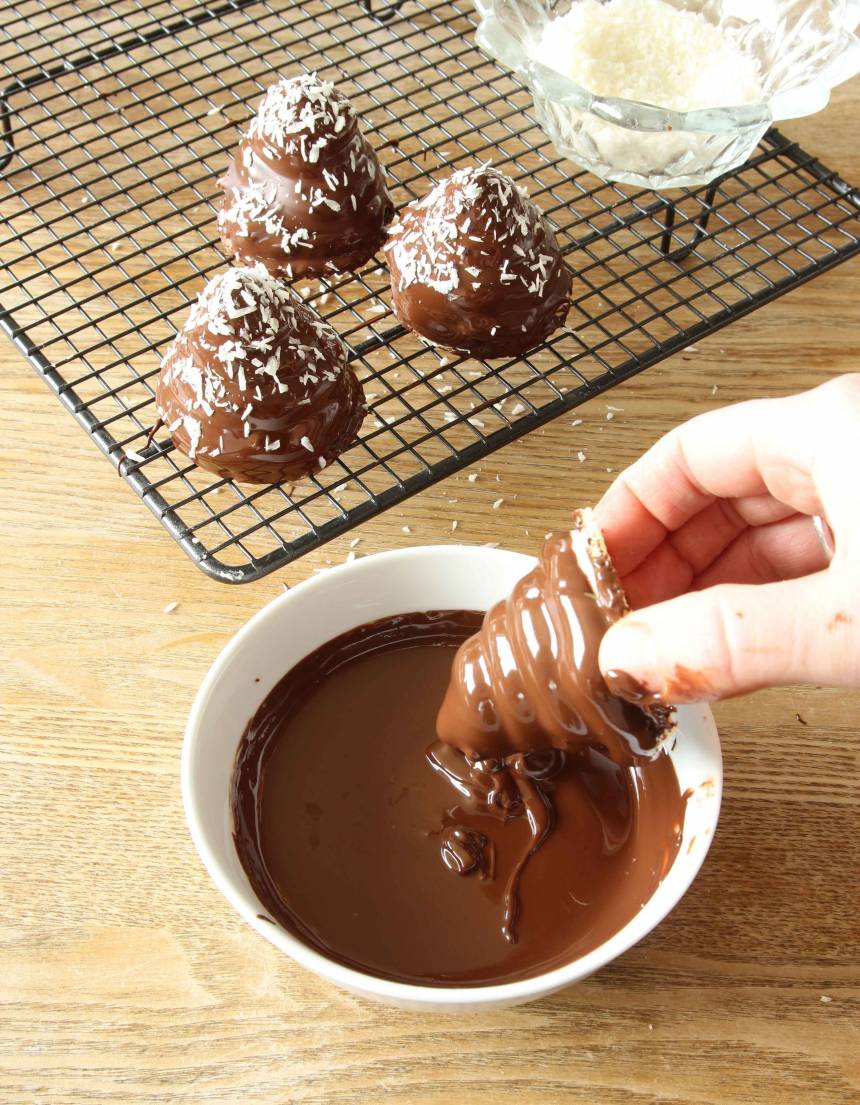 5. Smält chokladen över vattenbad och rör ner oljan till en slät smet. 7. Doppa mumsmumstopparna i chokladen och ställ den på ett galler. Strö över lite kokos. Låt chokladen stelna. Förvara dem i kylskåp.