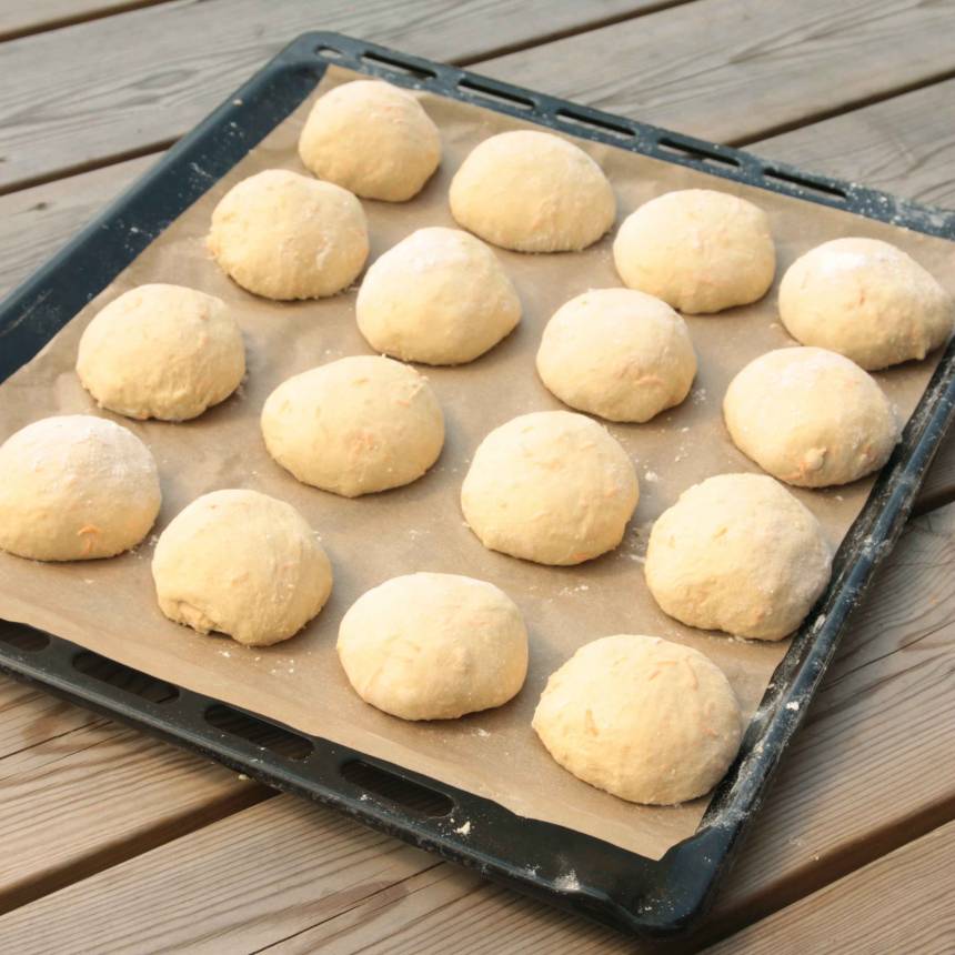 3. Rulla ca 16 runda bullar av degen och lägg dem på en plåt med bakplåtspapper. Låt dem jäsa under bakduk i ca 30 min. Sätt ugnen på 250 grader.