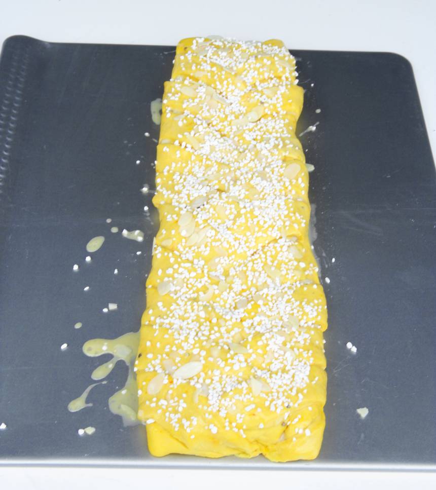 6. Pensla flätan med uppvispat ägg och strö över mandelspån och pärlsocker.