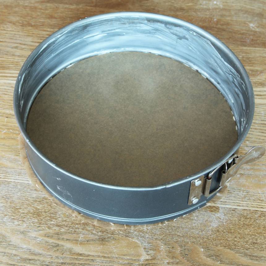 2. Smörj kanten på en springform, ca 24 cm i diameter. Kläm fast ett bakplåtspapper i botten och klipp bort kanterna som sticker ut. Knäpp upp formen igen.