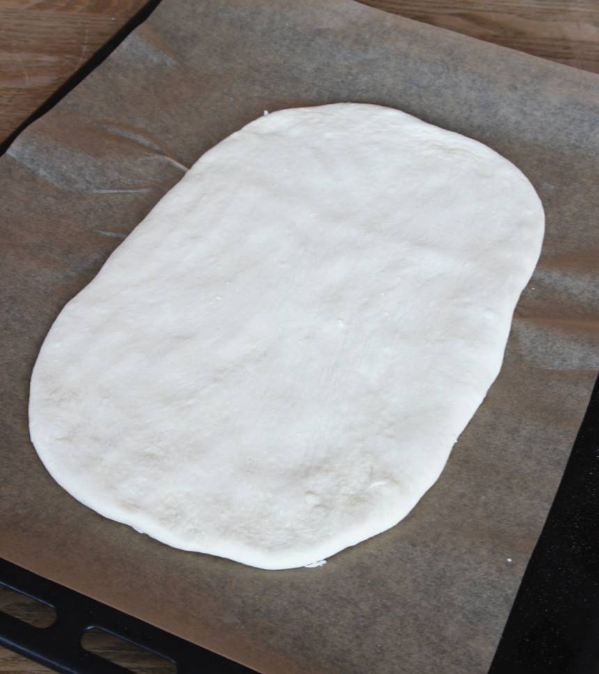 2. Tryck ut degen på en plåt med bakplåtspapper, 1 1/2–2 cm tjock. Låt den jäsa under bakduk i 50–60 min. Sätt ugnen på 230 grader.