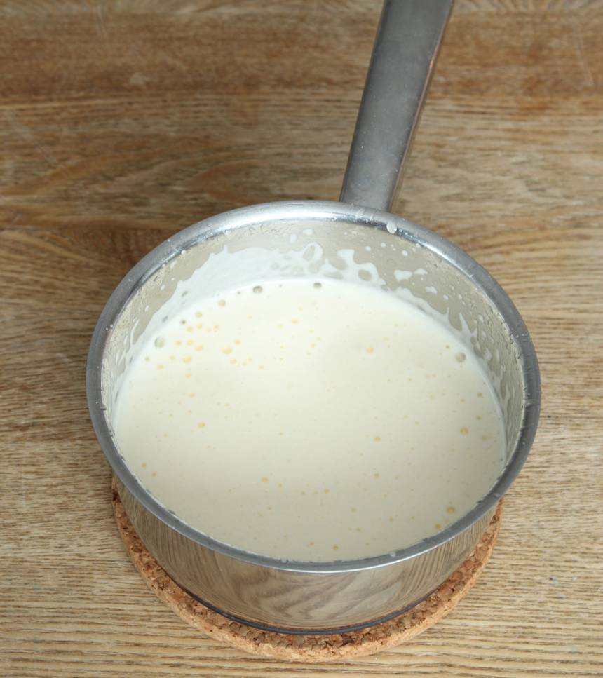 6. Koka upp socker och vatten. Stäng av plattan. Tillsätt äggulorna och vispa kraftigt med en elvisp till en krämig smet.