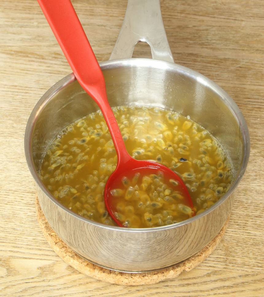 9. Häll juicen i en kastrull och låt den sjuda i ca ½ min. Stäng av värmen och smält ner gelatinbladen. Blanda ner kärnorna och fruktköttet från passionsfrukterna. Låt den svalna.