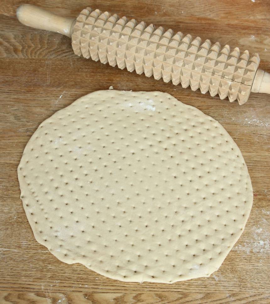 2. Dela degen i ca 4 bitar. Kavla ut dem till runda kakor, ca 27 cm i diameter. Kavla sista varvet med en kruskavel. Nagga ordentligt med en gaffel om du inte har någon kruskavel.