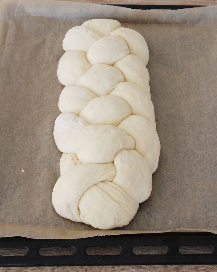 6. Lägg flätan på en plåt med bakplåtspapper och låt den jäsa i ca 30 min. Fäst ändarna ordentligt under flätan så de inte åker upp under gräddningen. Sätt ugnen på 230 grader.