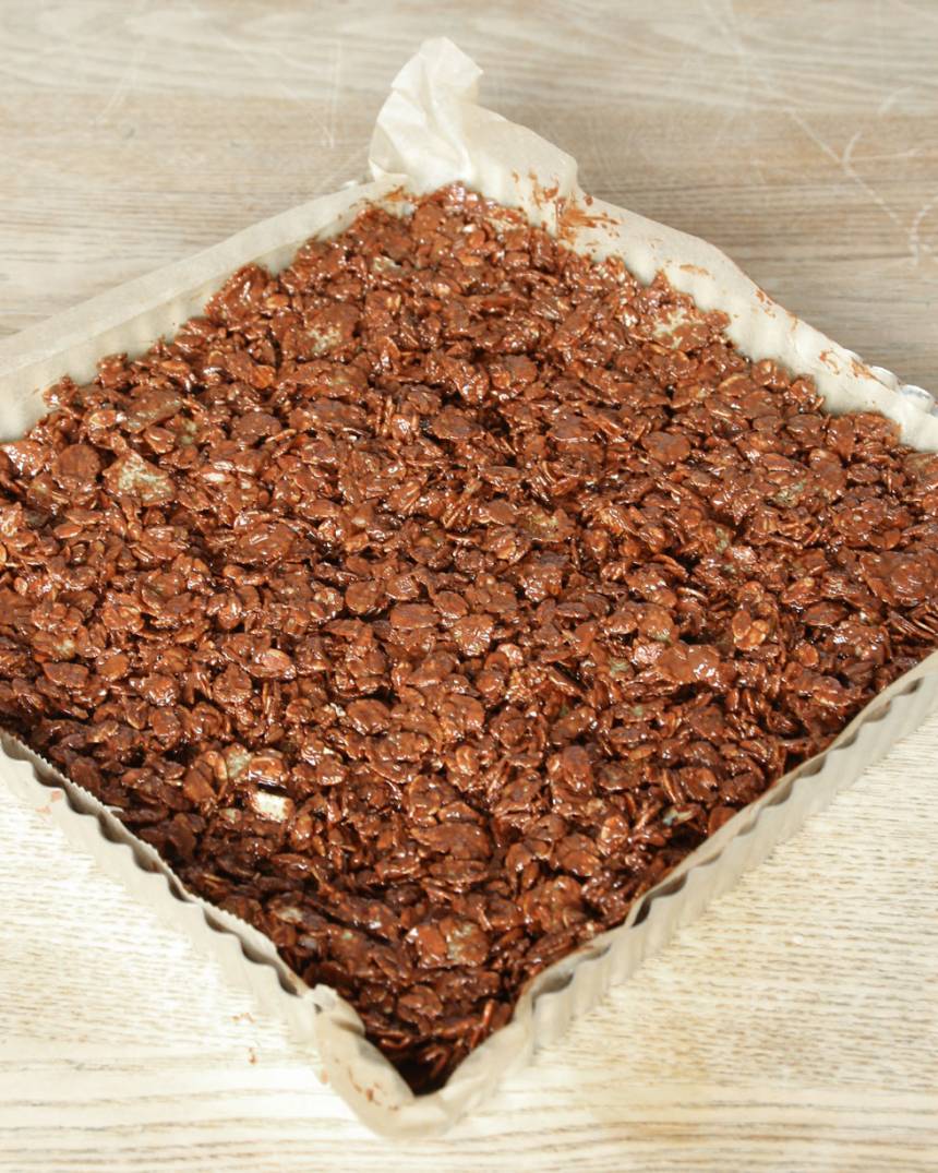 4. Bred ut müsliblandningen på ett bakplåtspapper, ca 2 cm tjock eller i en form med kanter klädd med bakplåtspapper, ca 21 x 21 cm.