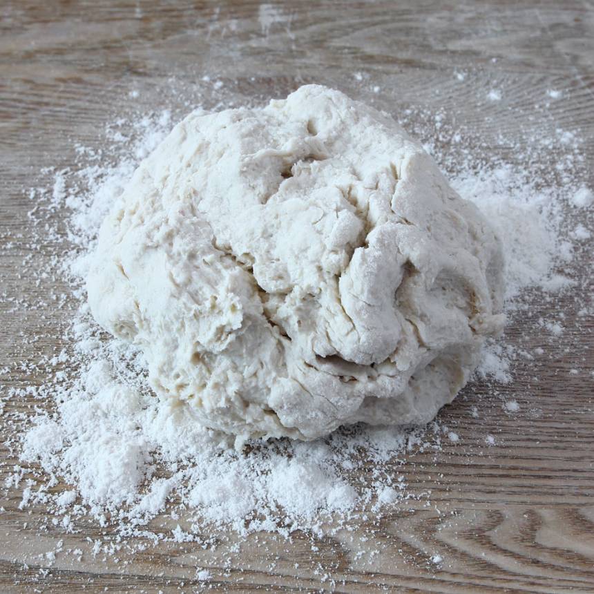 1. Nyp ihop smöret med de torra ingredienserna. Tillsätt filmjölken och blanda ihop allt till en kladdig deg. Rulla den kladdiga degen ett varv i vetemjöl så den inte klibbar fast på bordet och i händerna.