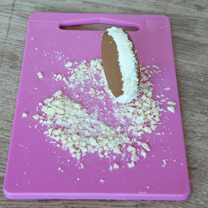 4. Rulla kanten med glass i hackad choklad. Lägg direkt in den färdiga glassbakelsen i frysen innan du gör nästa.