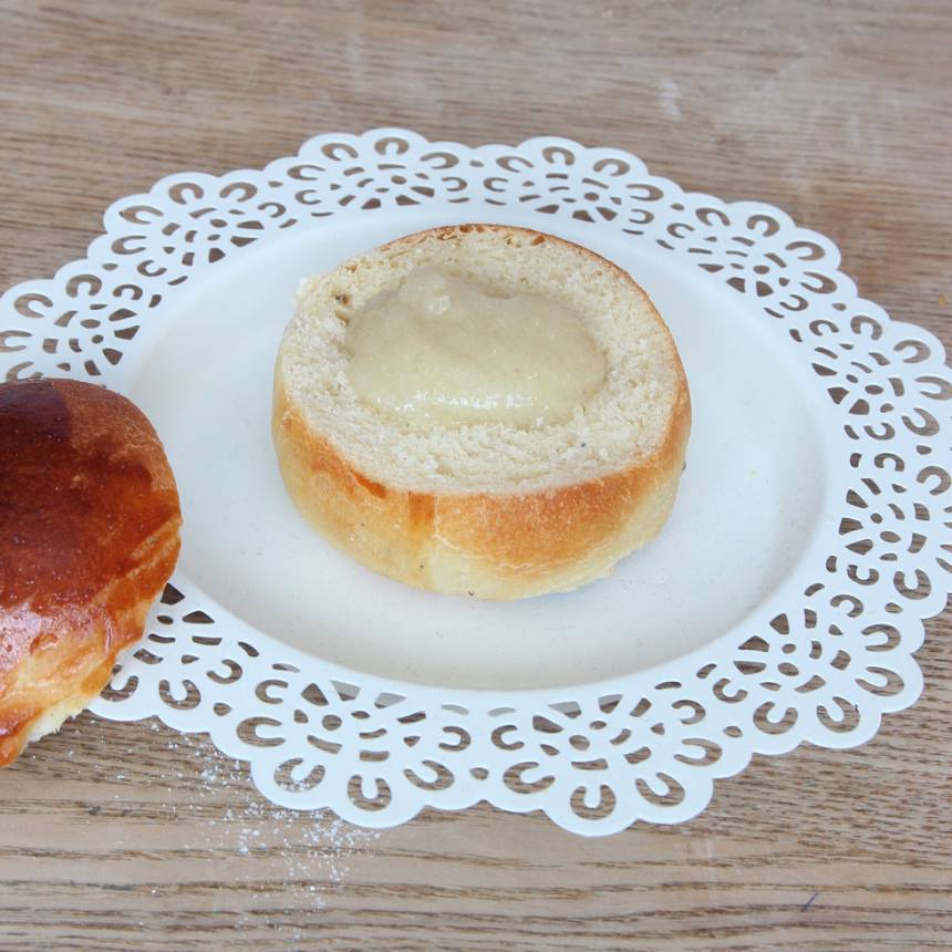 5. Montering: Skär av ett lock på varje bulle. Gröp ur lite inkråm ur bullarna. Blanda ihop mandelmassan med mjölken till en kladdig massa. Lägg en klick i varje bulle.