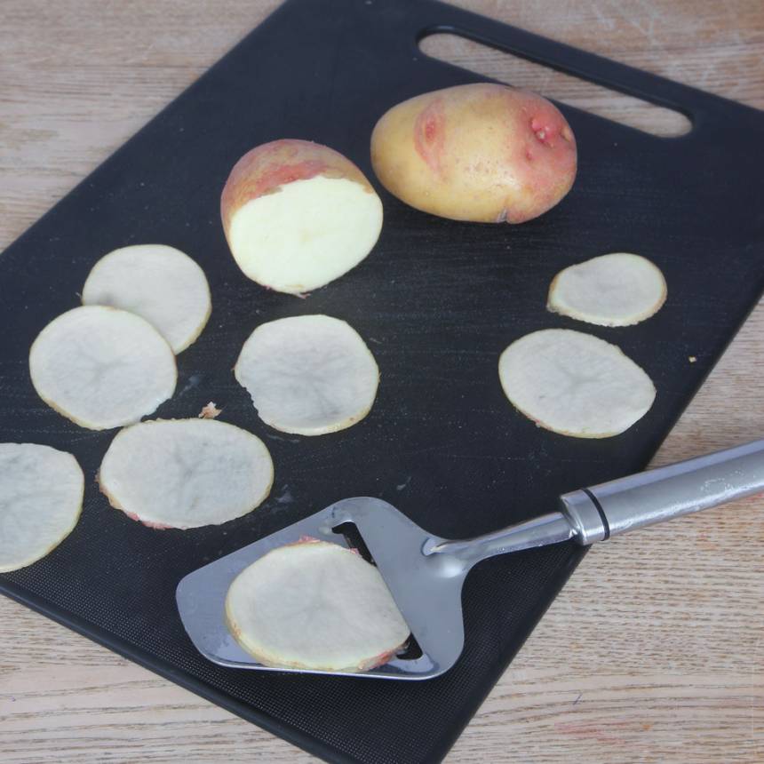 2. Tvätta potatisarna noga och torka dem torra. Skiva potatisarna tunt med en osthyvel.
