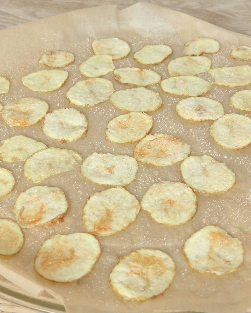 4. Kör potatisarna i mikron i 5–9 min tills de får en gulbrun färg. Tiden varierar beroende på hur många potatisskivor du har och vilken styrka din mikro har. Om du har en liten mikro och bara får plats med en vanlig måltidstallrik får du köra en potatis i taget. Då tar det 3–4 minuter i mikron. Låt potatisarna kallna på pappret.