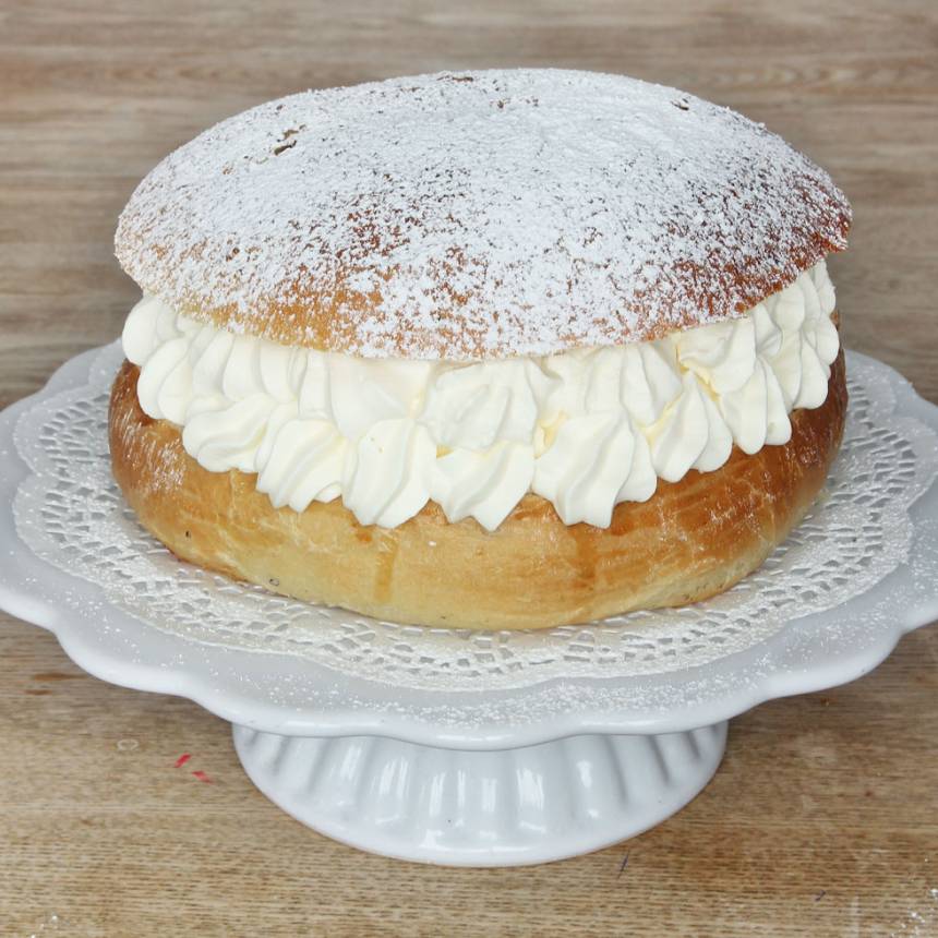 7. Vispa grädden fluffig och bred ut den, eller spritsa ut den över hela bottnen. Lägg på locket. Pudra över florsocker före servering.