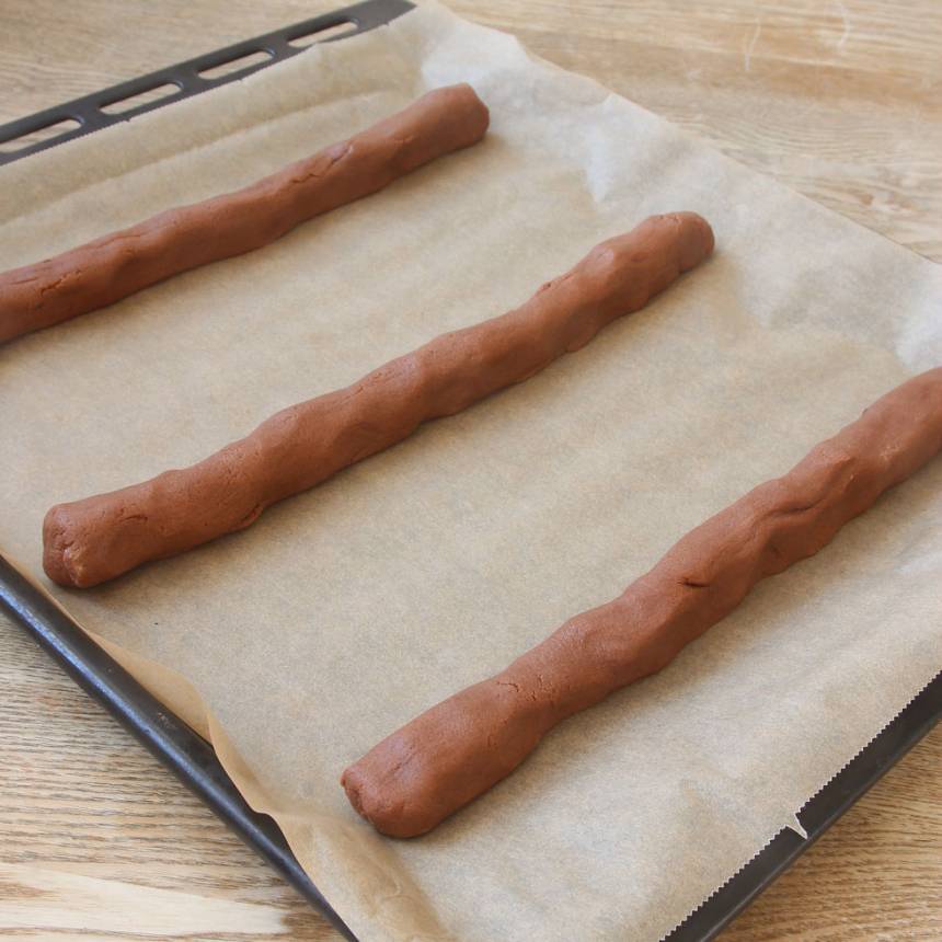 3. Rulla ut degbitarna till längder, ca 25 cm långa. Lägg 3 längder var brett isär på två plåtar med bakplåtspapper.