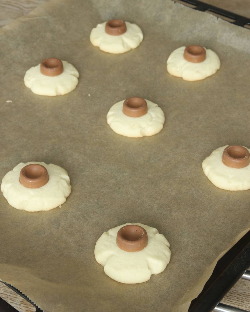 6. Lägg en schweizernötsbit på varje kakan medan de fortfarande är varm, men vänta ca 1 minut innan du lägger på den. Låt chokladen stelna (gärna i kylen).