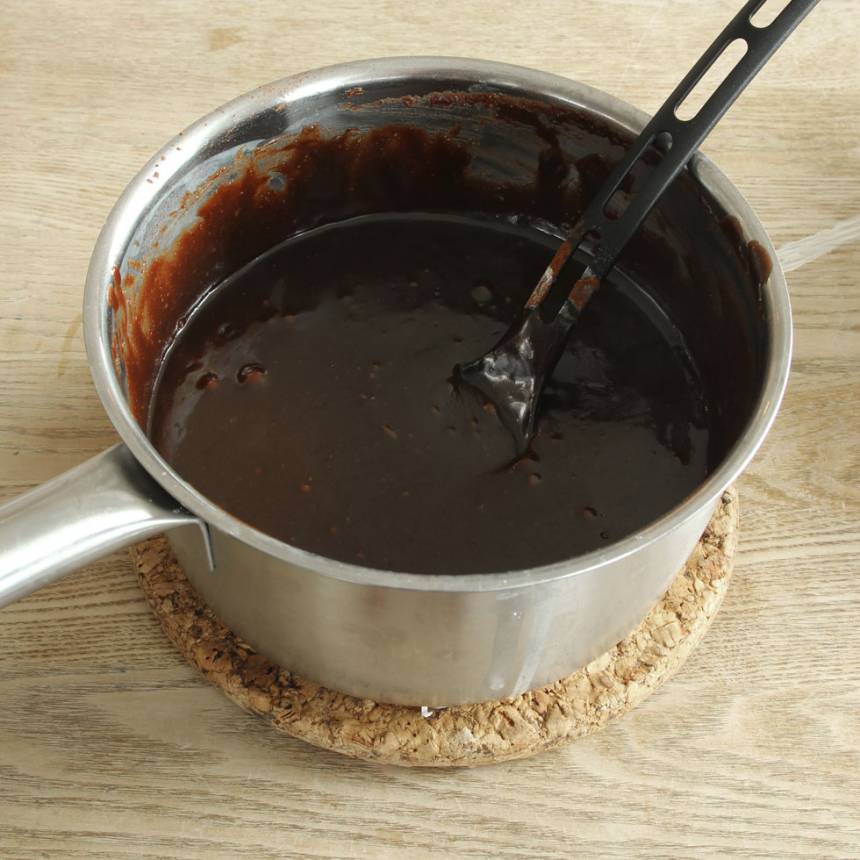 1. Sätt ugnen på 180 grader. Smält smöret i en medelstor kastrull. Ta bort den från värmen. Rör ner strösocker, sirap, vaniljsocker, kakao, vetemjöl och ägg. Blanda ihop allt till en slät smet. Blanda i chokladen.