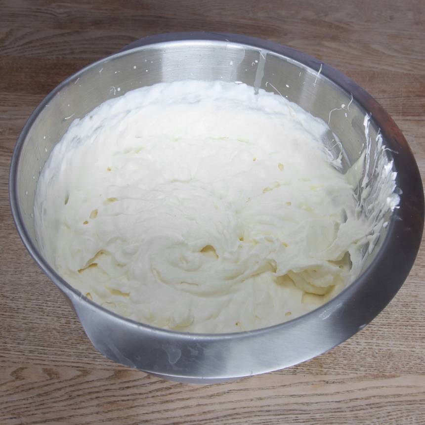1. Vispa grädden fluffig, men inte för fast för då blir moussen grynig. Tillsätt den vita, smälta chokladen samt äggulan.