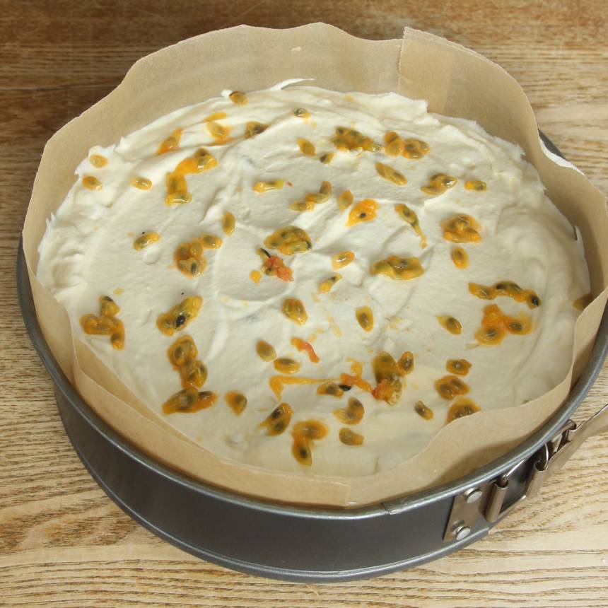 4. Bred ut gräddblandningen på smulbottnen. Garnera med passionsfrukt. Ställ tårtan i frysen i ett par timmar och ta fram den en stund innan servering. Låt den mjukna något innan den äts.
