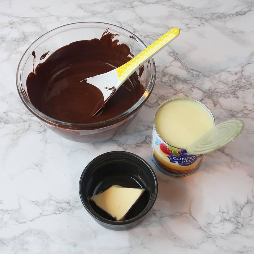 2. Smält chokladen ihop med smöret i en skål över vattenbad. Öppna burken på den kondenserade mjölken.