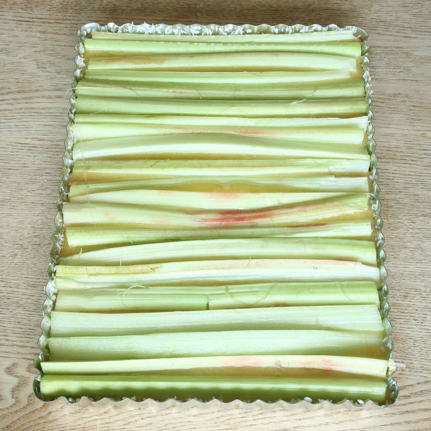 5. Lägg rabarberstavarna tätt intill varandra ovanpå smeten.