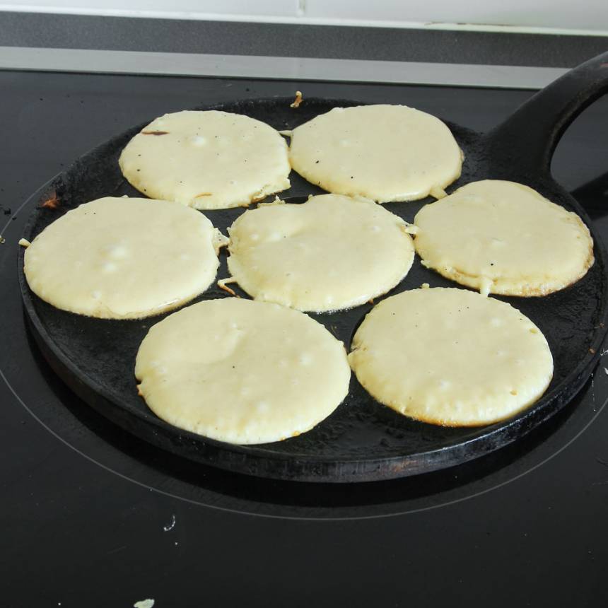 2. Värm upp ett plättjärn och lägg i en klick smör. Häll i smet och grädda på låg värme (eller klicka ut smet i små rundlar i en stor stekpanna). Kontrollera värmen så de inte bränns.
