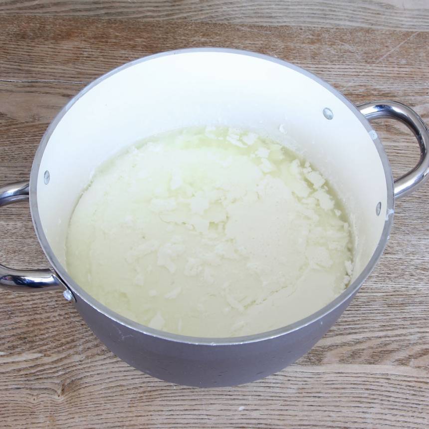 3. Häll tillbaka mjölk- och yoghurtblandningen i kastrullen. Rör om ordentligt. Fyll upp varmvatten i diskhon och ställ kastrullen i det varma vattenbadet med en lock ovanpå. Låt yoghurten stå och tjockna i 8–10 timmar (vattnet svalnar långsamt och ska inte fyllas på). Men om yoghurten inte tjocknat tillräcklig efter den långa tiden så fyll upp med nytt varmt vatten i diskhon och låt den stå en stund tills den tjocknar. När yoghurten är klar har den tjocknat och vätskan har separerats från den.
