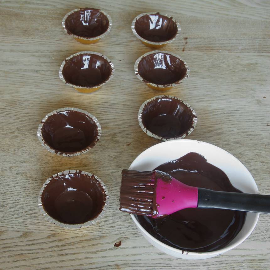 2. Pensla insidan på aluminiumformarna med choklad. Ställ dem i kylen för att stelna.