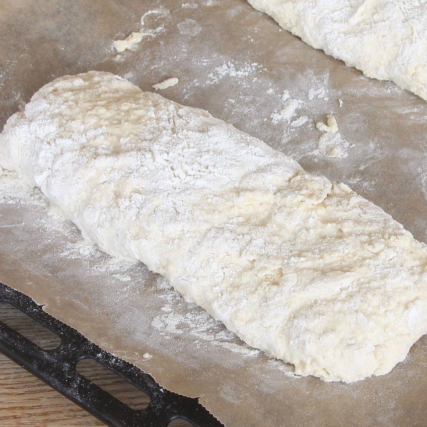 2. Forma degen till en limpa på en plåt med bakplåtspapper. Obs! Använd ordentligt mjölade händer så degen inte fastnar i händerna. Den ska vara kladdig.