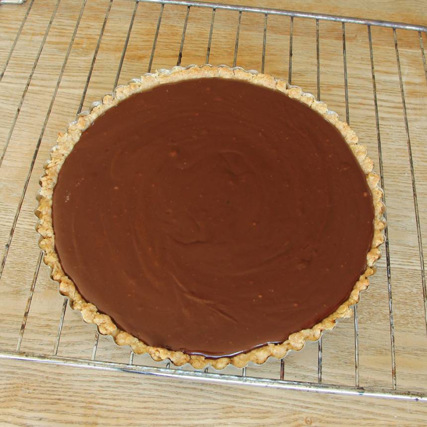 5. Häll chokladkolakrämen på pajbottnen. Låt den svalna. Ställ den i kylen för att stelna i ett par timmar.