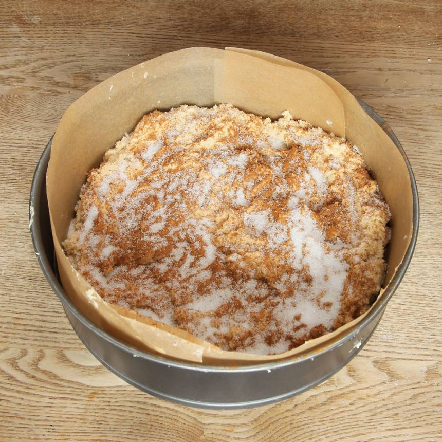 2. Fördela hälften av degen i en smord och bröad spring, form (eller klädd med bakplåtspapper). Strö över ett rivet äpple, strö över kanel och strösocker i valfri mängd.