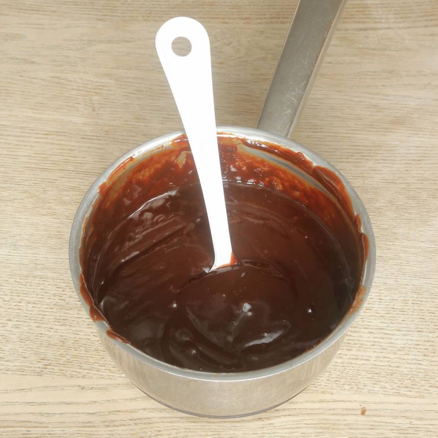 4. Tryffel: Värm upp vispgrädden i en kastrull. Bryt chokladen i bitar och smält ner den i grädden. Tillsätt smöret och rör om till en slät smet.