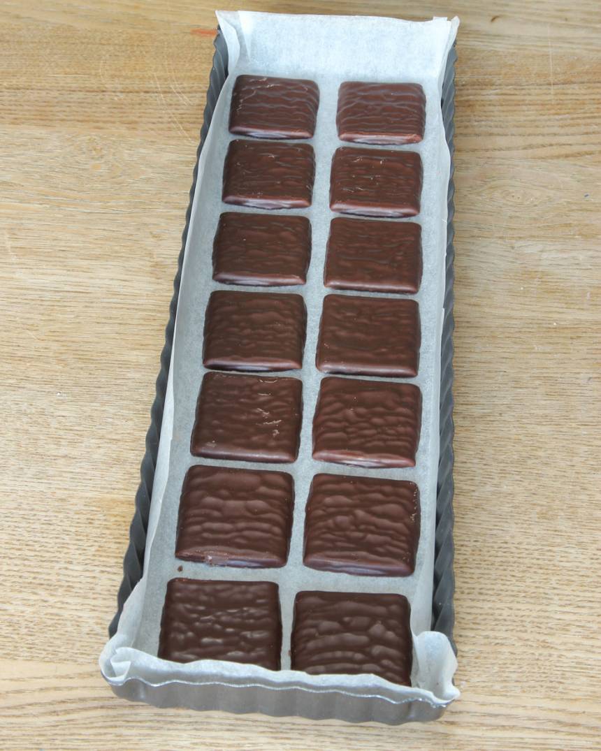 1. Testa att lägga ut After Eight plattorna i en form så du ser hur mönstret blir. (Det går bra att använda en rund form också, 22–23 cm i diameter, men du får man skära till chokladbitarna).