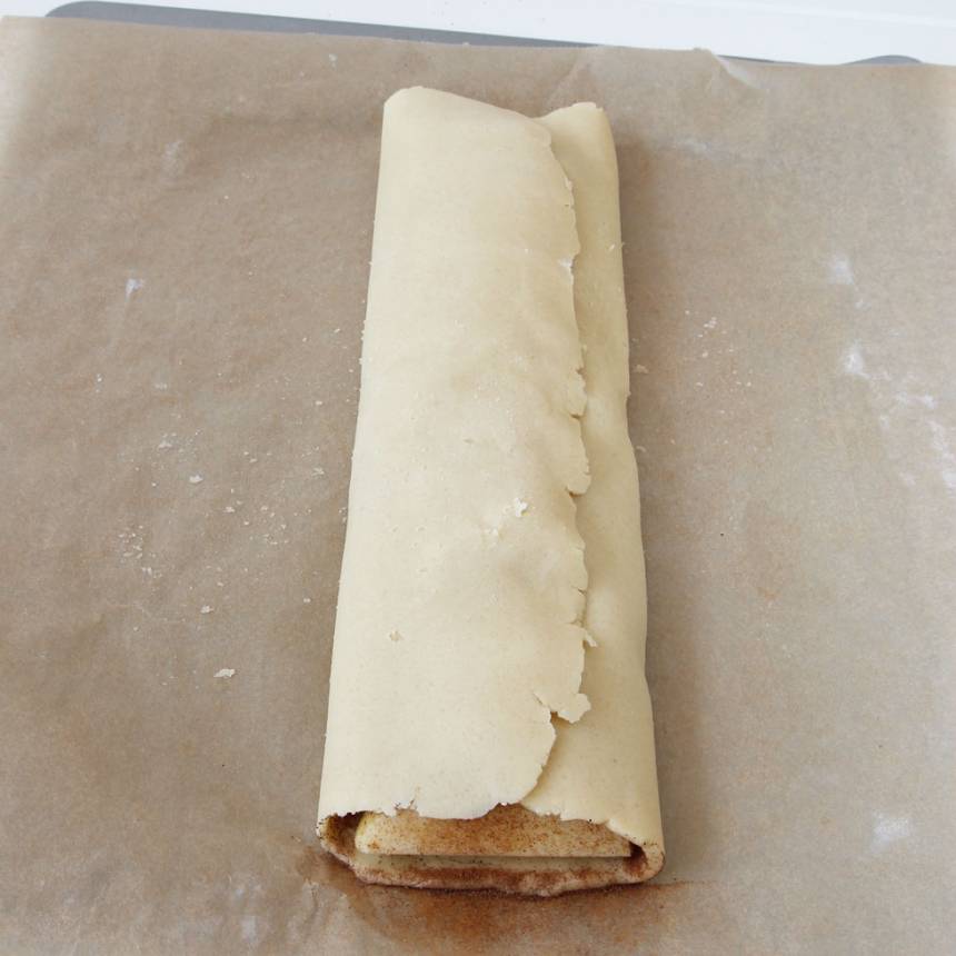 7. Vik den vänstra degkanten över den högra (vik med bakplåtspapperet och drag sedan bort det).