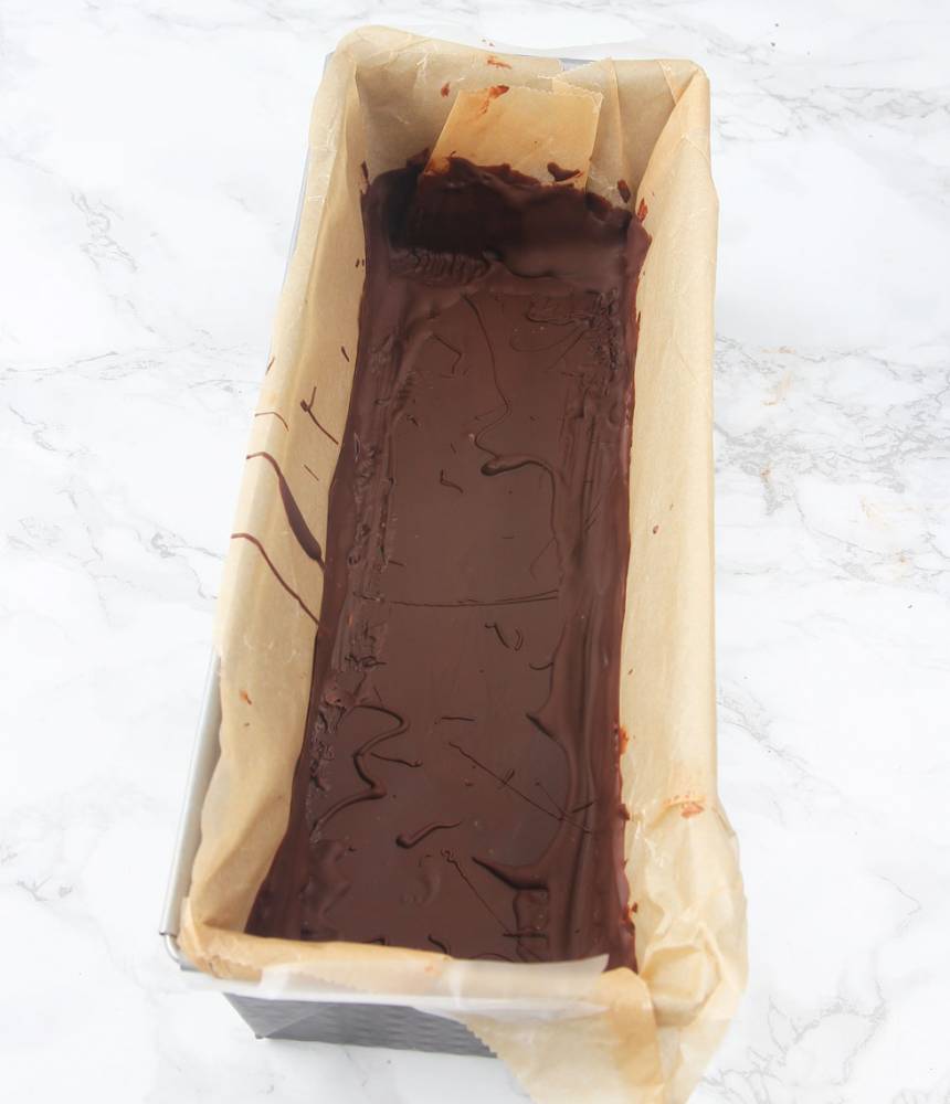 3. Häll ca 2/3 av chokladen i formen. Pensla upp choklad ca 5 cm upp på kanterna. Ställ formen i kylen för att stelna.