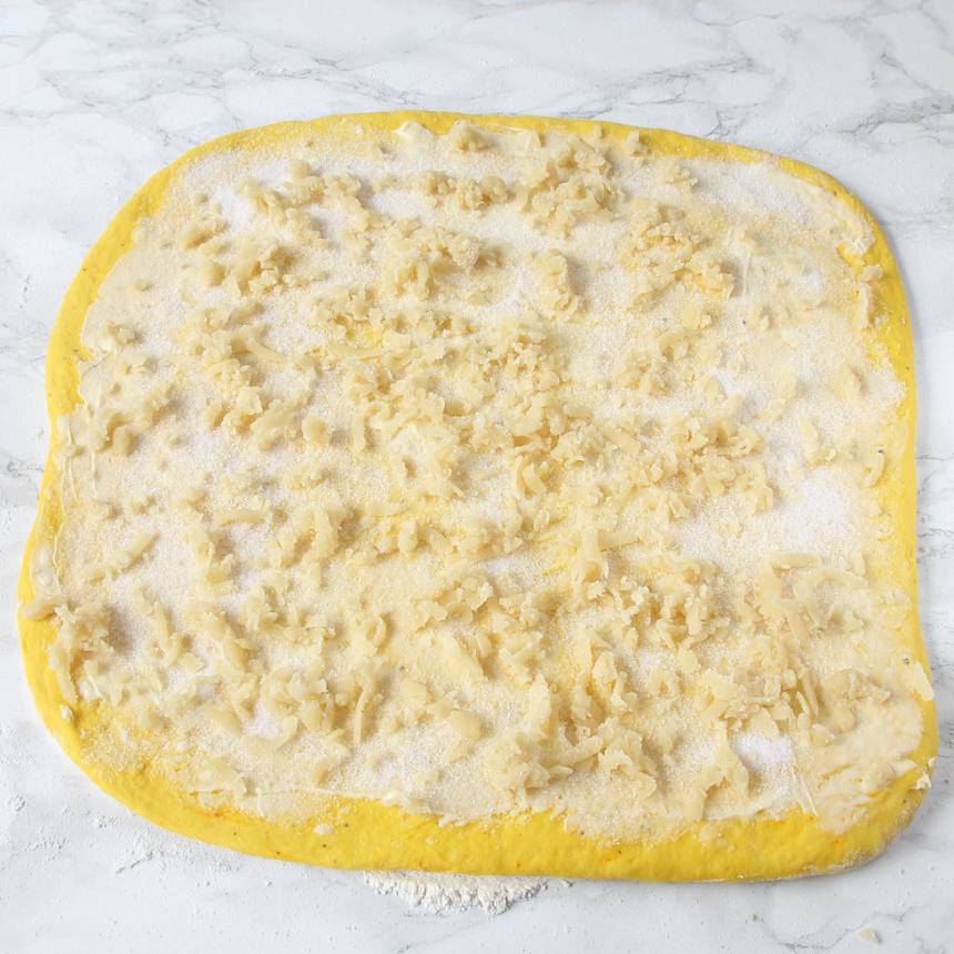 4. Bred ut hälften av smöret på degplattan och strö över hälften av strösockret och vaniljsockret. Strö över mandelmassan (eller vaniljsocker/vit choklad).
