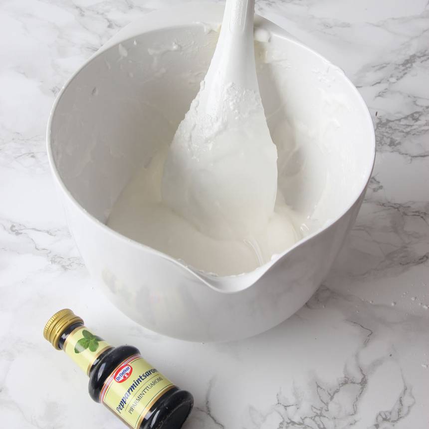 2. Tillsätt pepparmintsarom och florsocker (mängden florsocker kan variera något eftersom äggens storlek varierar). Den ska vara ganska fast, men ändå spritsbar. Rör om ordentligt.
