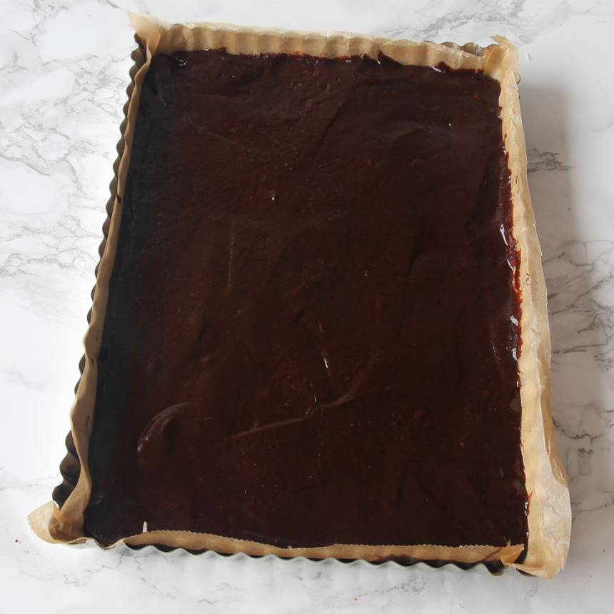 3. Lägg i ett bakplåtspapper i formen eller smörj och bröa. Häll smeten i formen och bred ut den med en slickepott. (Det går också att göra kakan i en rund form, 23–24 cm i diameter).