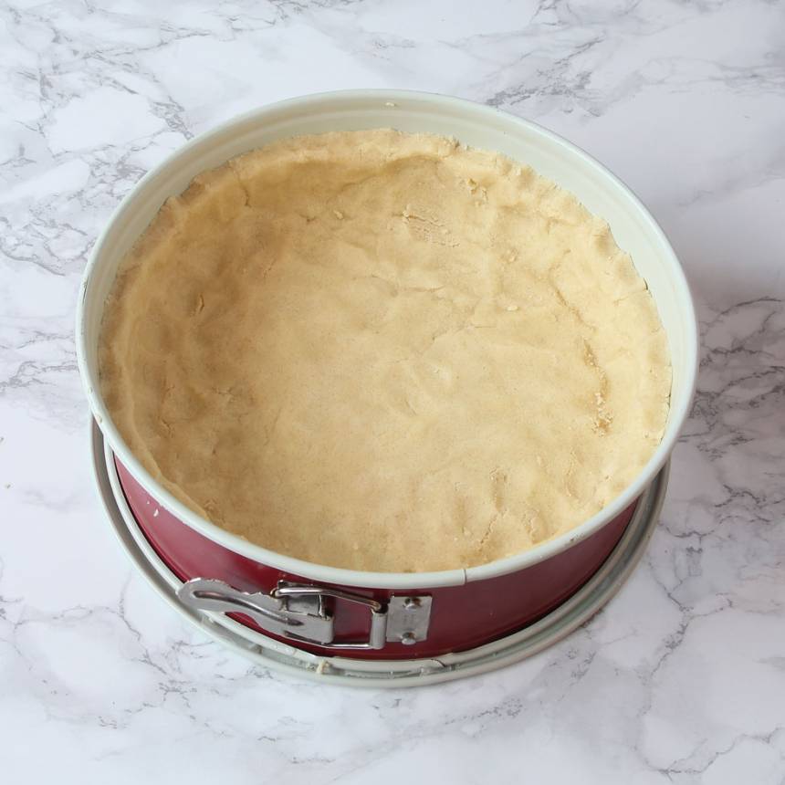 2. Tryck ut degen i en form med löstagbar kant, 23–24 cm i diameter klädd med bakplåtspapper i botten. Degen ska sticka upp några centimeter på kanterna.