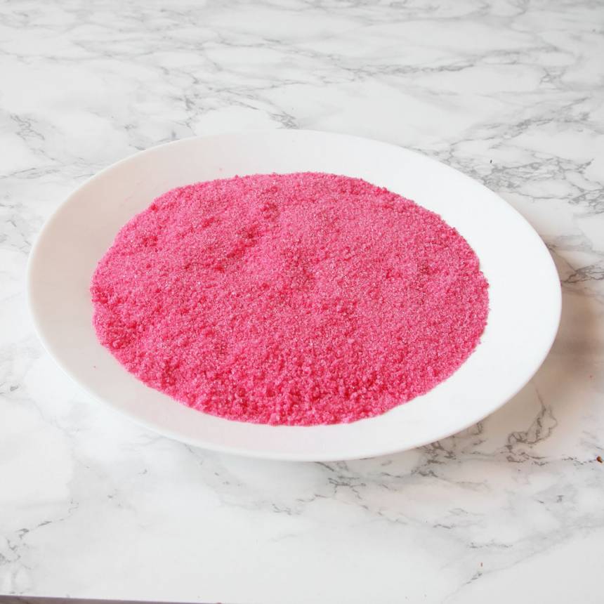1. Sätt ugnen på 160 grader. Börja med garneringen: Blanda socker och hushållsfärg i en plastpåse så att sockret färgas svagt rosa. Sprid ut sockret på en skärbräda av plast.