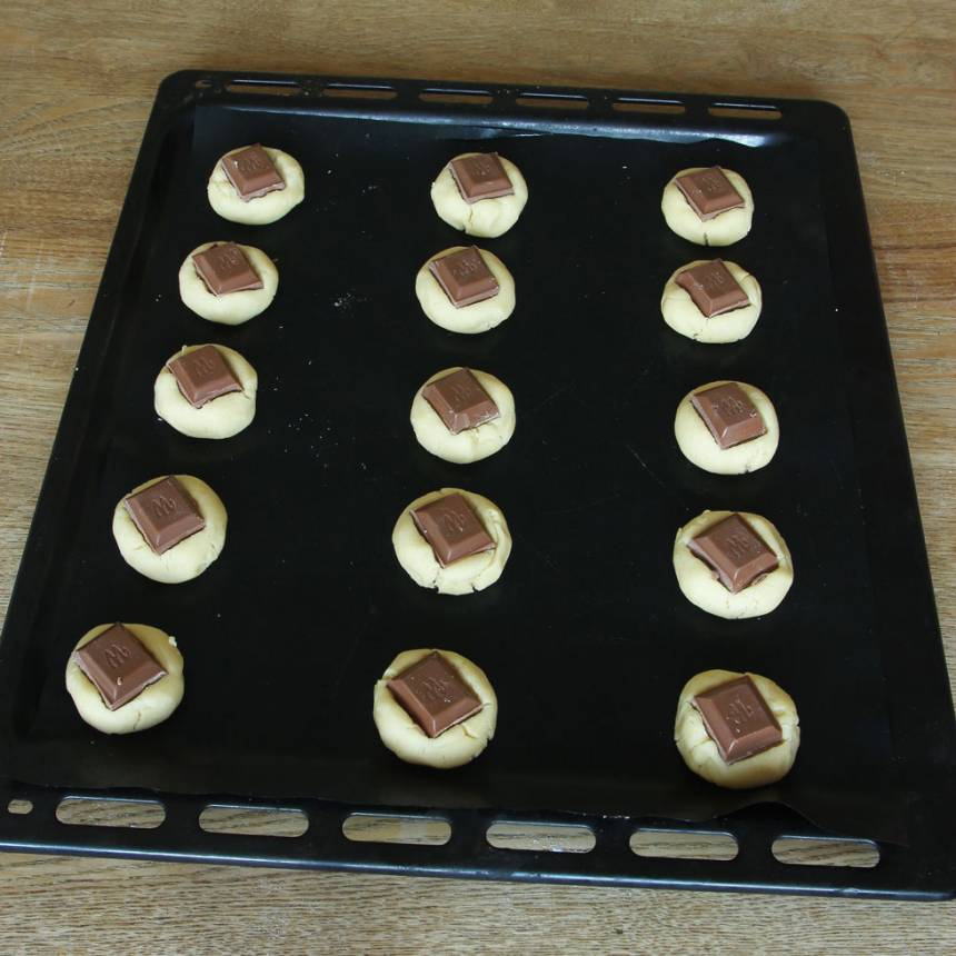 4. Lägg en chokladbit på varje boll och tryck till lite.