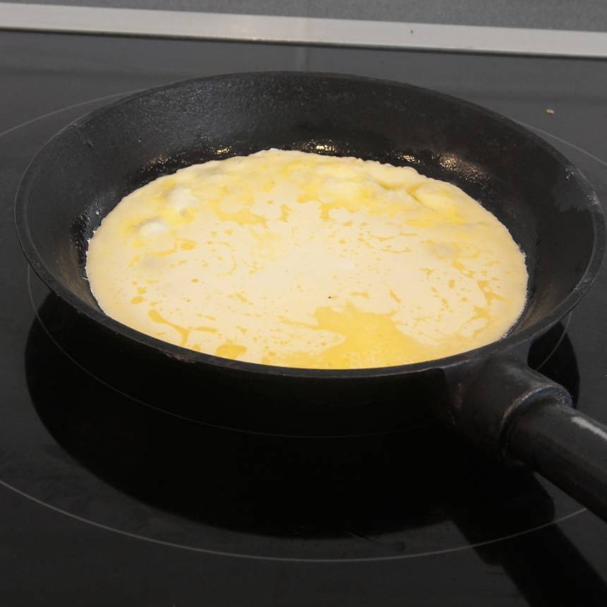 4. Häll ett tunt lager smet i stekpannan. Sänk värmen ett par steg. Vänd pannkakan när smeten börjar stelna.