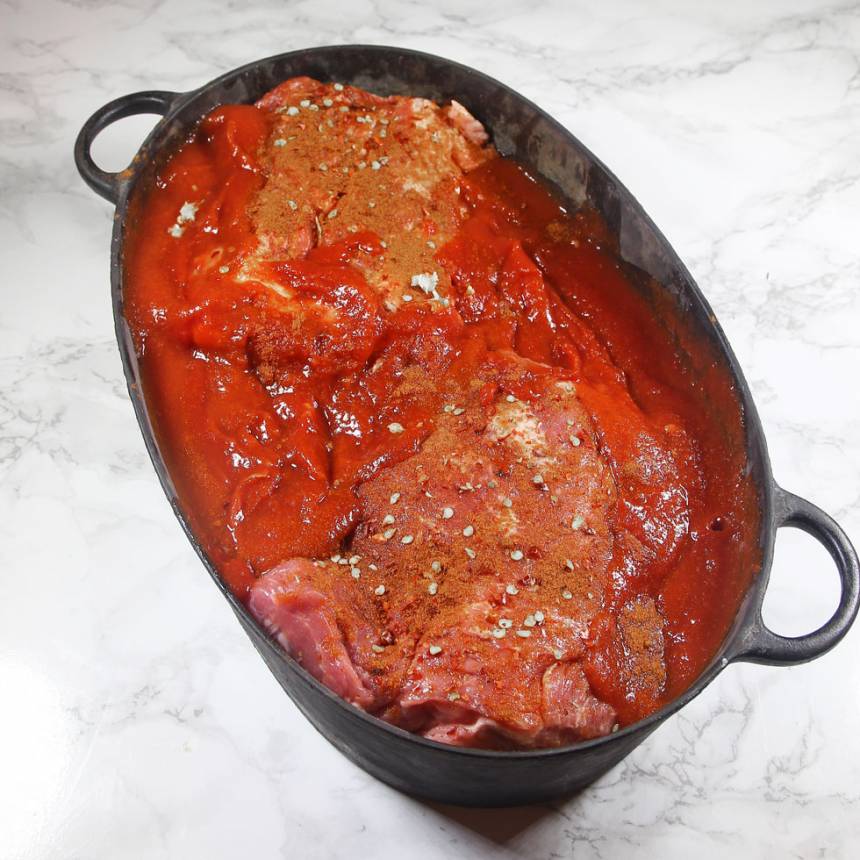 2. Blanda de passerade tomaterna med chilisåsen och häll det runt köttet i grytan.