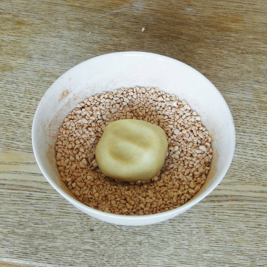 4. Doppa ovansidan av kakorna i socker- och kanelblandingen. Tryck till lite så pärlsockret fastnar. Lägg dem på en plåt med bakplåtspapper.