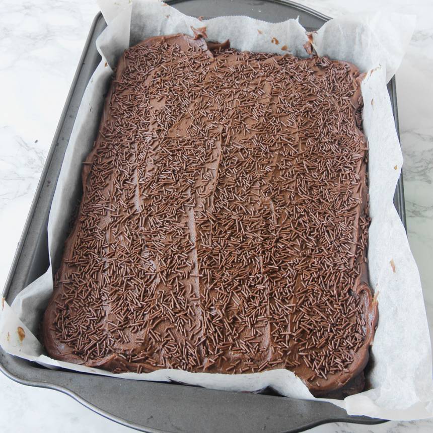6. Strö chokladströssel över glasyren innan den stelnar. Låt glasyren stelna. Skär kakan i rutor med en vass kniv.