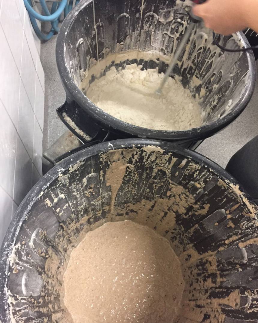 Vi matar surdegar och vispar med en betongborr för att orka röra runt i tunnorna. Den övre surdegen är en vetesurdeg och den undre en rågsurdeg.
