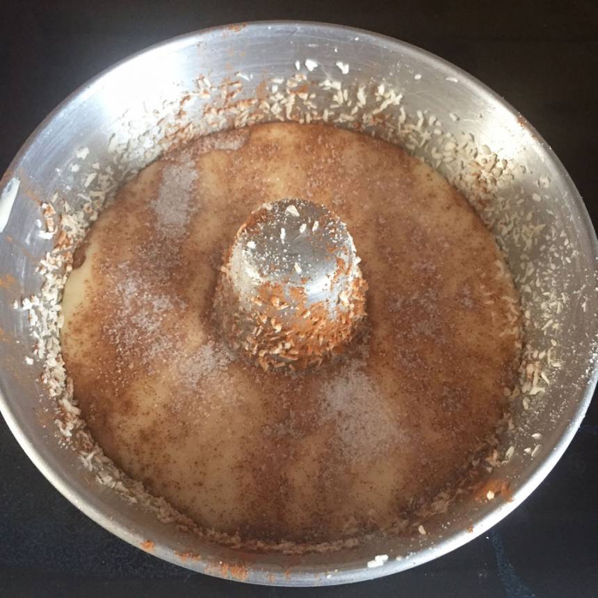4. Häll över hälften av smeten som är kvar i bunken. Pudra på hälften av kanel- och sockerblandningen. Häll över den sista smeten och pudra över den sista kanel- och sockerblandningen.