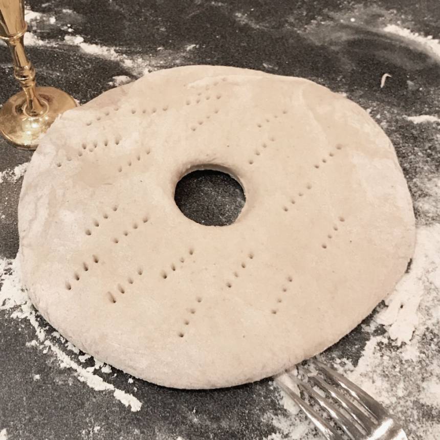 3. Stansa ut ett hål i mitten, ca 4 cm i diameter, med till exempel ett snapsglas. Nagga brödkakorna med en gaffel. Låt dem jäsa under bakduk i ca 30 min. Sätt ugnen på 220 grader.