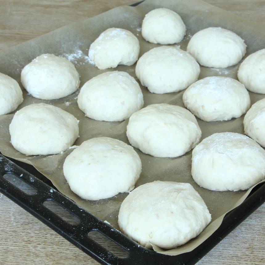 3. Dela degen i ca 20 bitar och forma dem till runda bollar. Lägg bröden på en plåt med bakplåtspapper och låt dem jäsa i 30 min. Sätt ugnen på 250 grader.